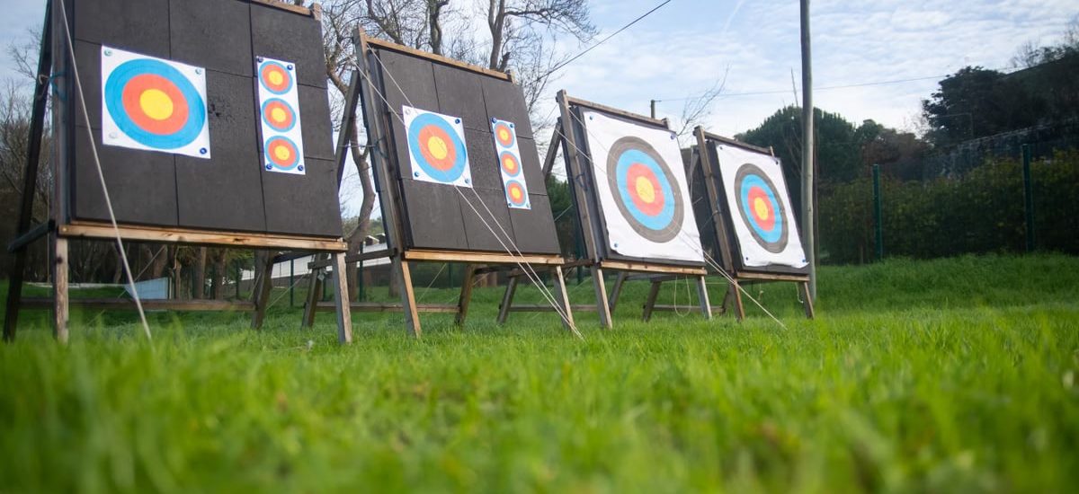 Archery targets on a lush green field outdoors, set for practice in Portugal.